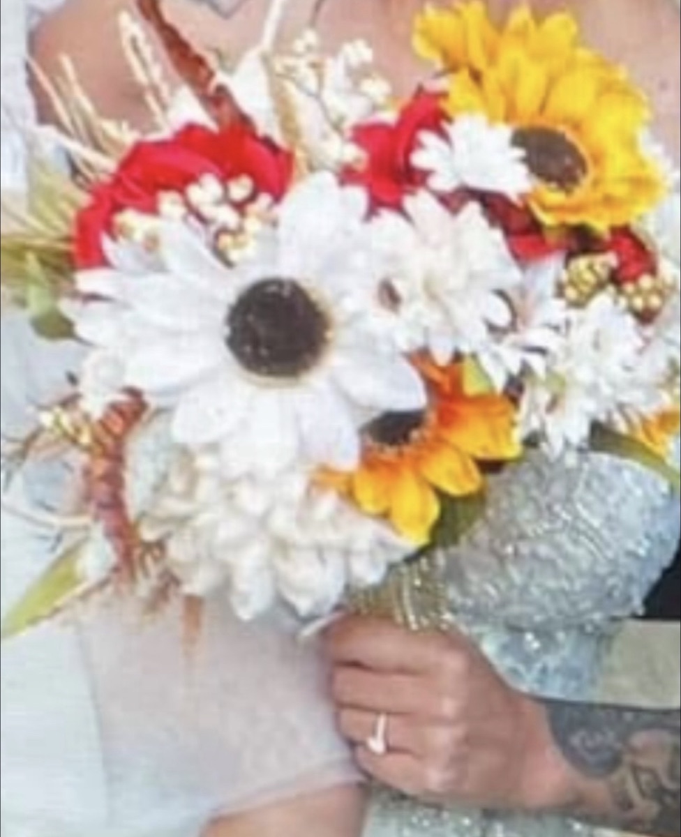 Bridal bouquet with white gerbera daisies, red roses, sunflowers, greenery and gold ribbon