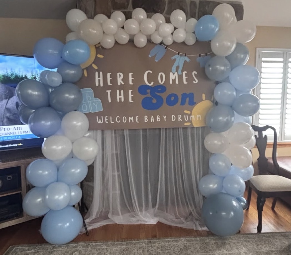 Here Comes the Son baby shower backdrop with blue and white balloon arch for Baby Drumm
