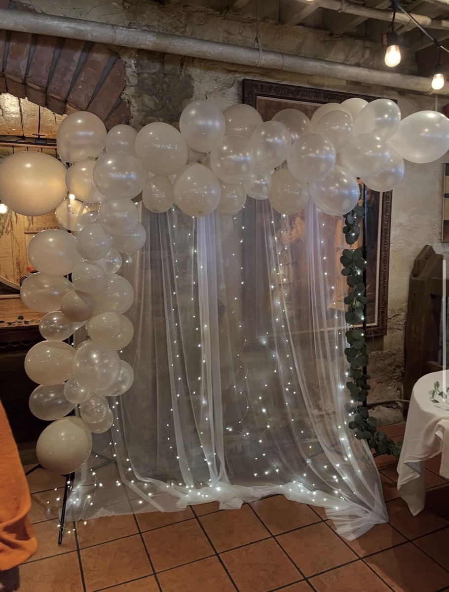 White pearl balloon garland with tulle and fairy lights at an intimate bridal shower